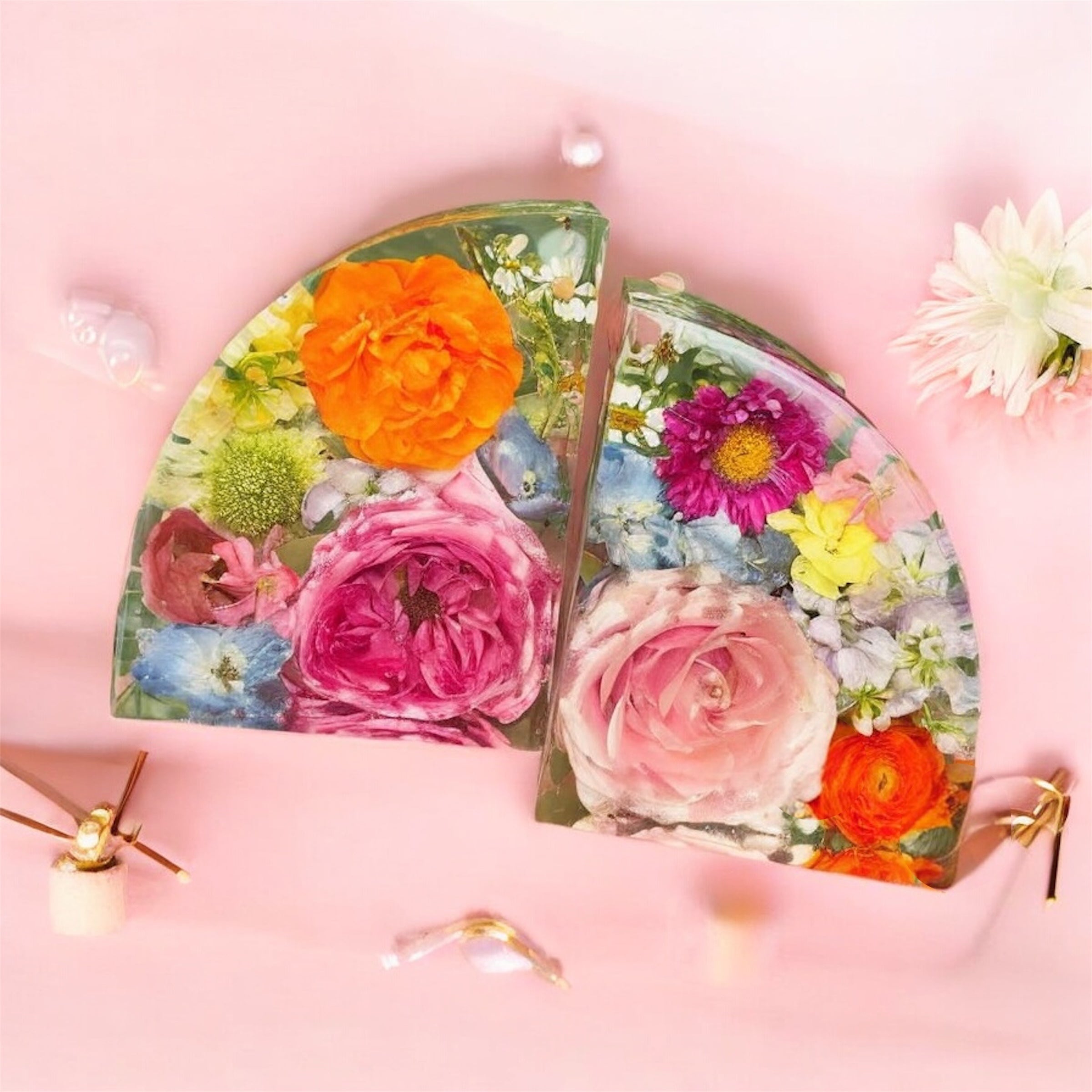 Handcrafted clear resin bookends with preserved flowers on a pink background