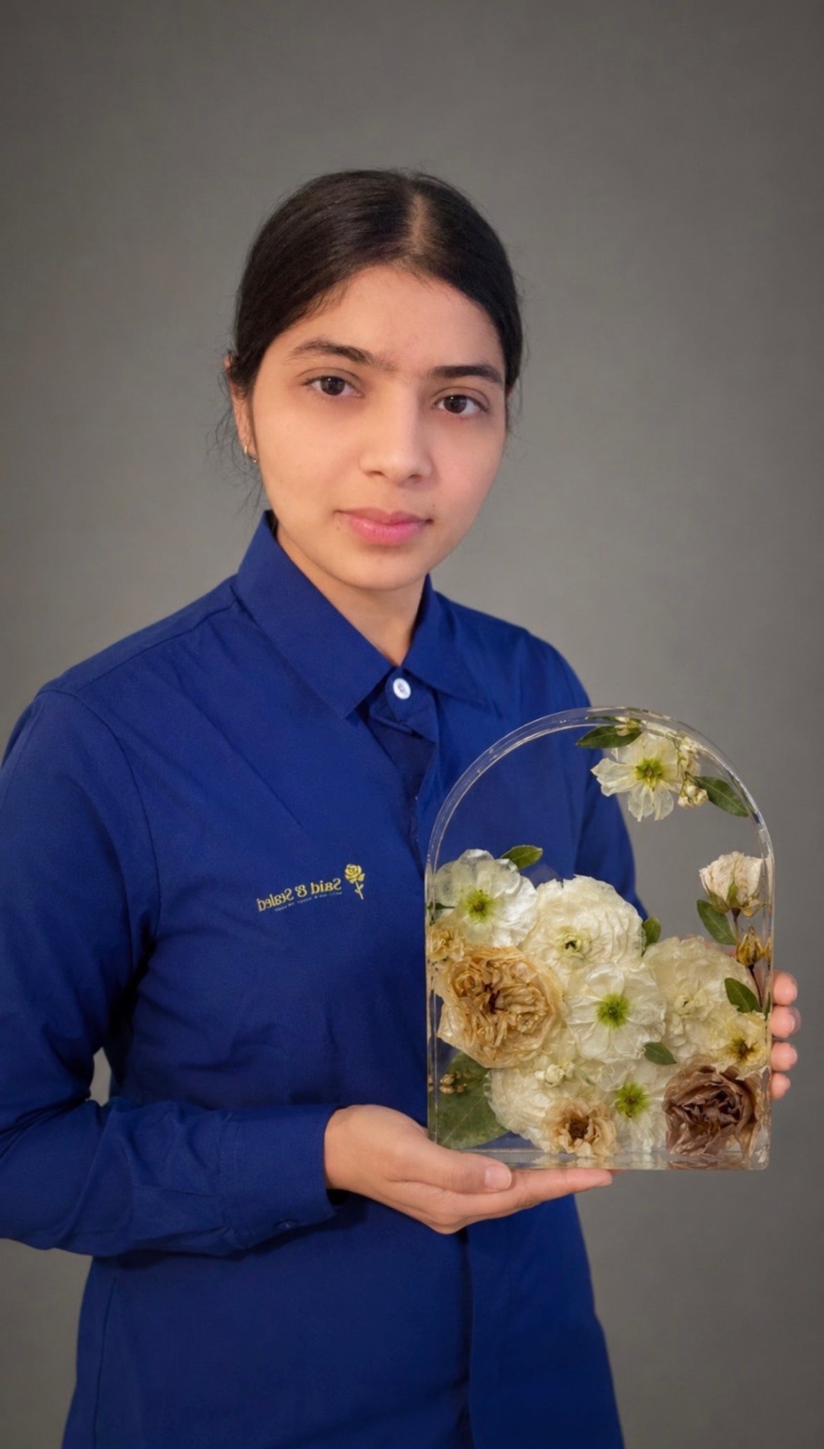 Artist holding an elegant grand resin arch flower preservation display piece for custom home decor
