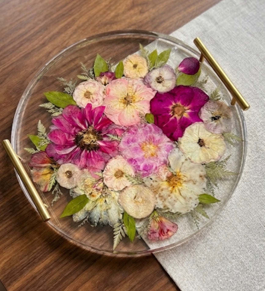 Round resin flower preservation tray with gold handles featuring a colorful wedding bouquet preserved in clear resin.